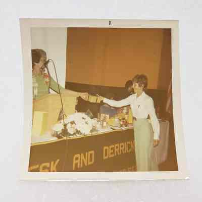 [Photo] Lady Receiving a Gift from Lady at Podium, Association of Desk and Derrick Clubs, Square, White Border, c.1972