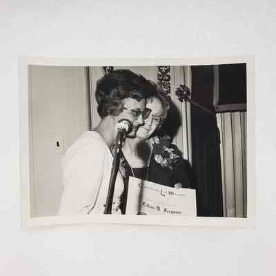 [Photo] Two Ladies at Microphone with Certificate of Service for Lillias M. Ferguson, Association of Desk and Derrick Clubs, Large, BW, Landscape, White Border, c.1972
