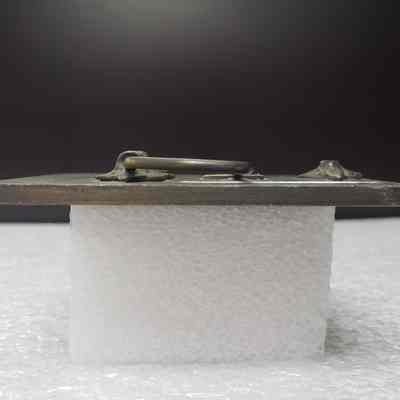 [Belt Buckle] Carnohan Enterprises Inc., Oilfield Construction, Antique-Bronze Orange Black [Broken] - Side: View from the side.