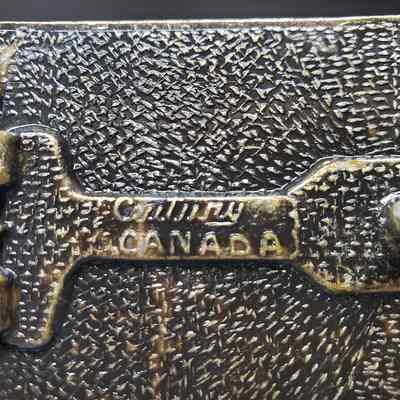 [Belt Buckle] Canadian Western Natural Gas, Wood Antique-Bronze - Maker's Mark: Close-up view of the maker's mark on the back.