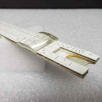 [Slide Rule] Union Carbide Chemicals and Plastics, White Plastic, Brown Leather - Side Slide Rule, Angled: Angled side view of slide rule