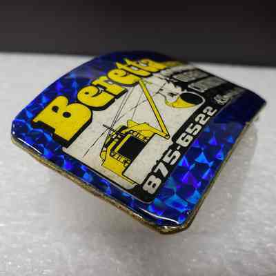 [Belt Buckle] Beretta Ent. Ltd. Oil field Construction, Holographic Blue Yellow [Broken] - Lamination, Angled: Angled view of the lamintion from the left-side.