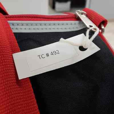 [Bag] Texaco Duffel, Black Red - Old Accession Tag: Close up of old accession tag attached to bag
