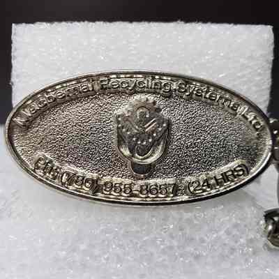 [Keychain] Macbernal Recyling Systems Ltd., Drill Head, Silver - Front, Oval Fob: Close-up view of front of oval fob.
