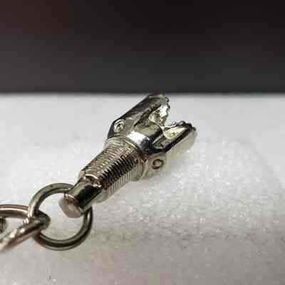 [Keychain] Macbernal Recyling Systems Ltd., Drill Head, Silver - Angled Base, Drill: Angled view of drill head attachment, base.