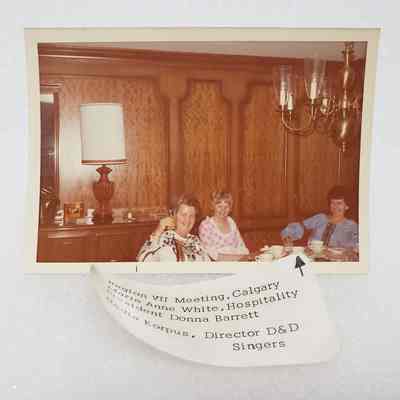 [Photo] Marie Anne White, Donna Barrett, and Nadia Korpus Seating in Dininf Room, Region VII Meeting Calgary, Association of Desk and Derrick Clubs, Landscape, White Border, c.1972