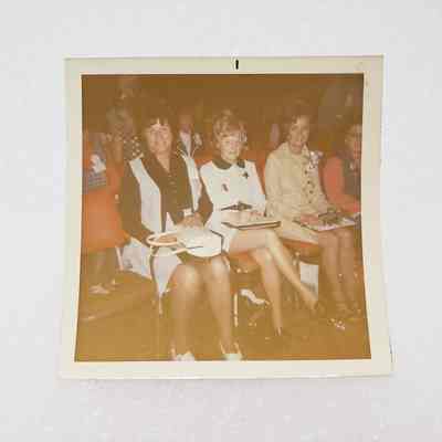 [Photo] Three Ladies Seated in an Auditorium on Red Chairs, Square, White Border, c.1972