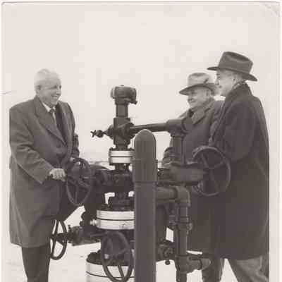 [Photo] Group of Three Men Around a Christmas Tree Valve, B&W, 8x10in