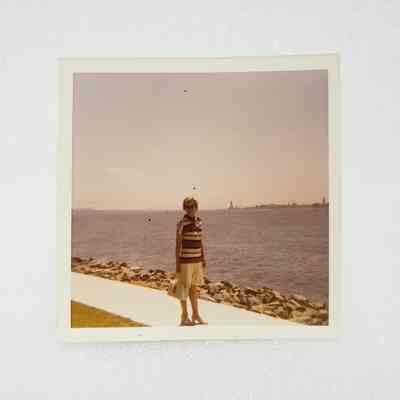 [Photo] Lady Standing on Waterfront Path with Bridge in Background, Instant Film, Square, c.1971