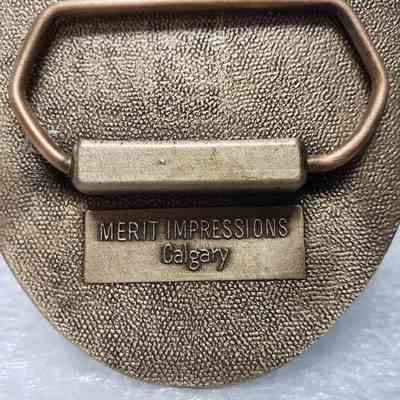 [Belt Buckle] Brelco Drilling Ltd., Antique-Bronze - Maker's Mark: Close-up view of the maker's mark, beneath the hinge.
