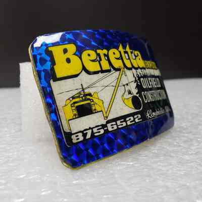 [Belt Buckle] Beretta Ent. Ltd. Oil Field Construction, Holographic Blue Yellow [Broken] Front, Angled: Angled view of the front, showing holographic patterning.