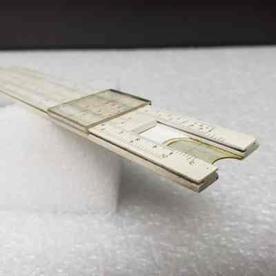 [Slide Rule] Dominion Bridge Co. Ltd./Riverside Iron & Engineering Works Ltd., White Plastic, Brown Leather - Side Slide Rule, Angled: Angled side view of slide rule