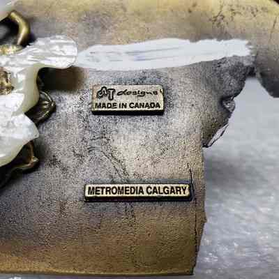 [Belt Buckle] Triton Project Inc./Nova/Cooper Industries, Clarkson Valley Compressor Station, 1991, Antique Bronze - Maker, Close-Up: Close-up view of makers mark on back.