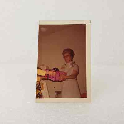 [Photo] Lady Receiving Pink and Blue Wrapped Gift, Cropped, Association of Desk and Derrick Clubs, Square, White Border, c.1972