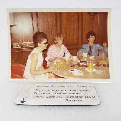 [Photo] Three Ladies Seated at a Round Table with Drinks, Region VII Meeting Calgary, Association of Desk and Derrick Clubs, Landscape, White Border, c 1972