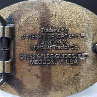 [Belt Buckle] CAT L Series Tractors, 1982, Antique-Bronze - Maker's Mark: Close-up view of the maker's mark on the back.
