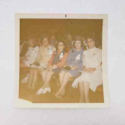 [Photo] Four Ladies Seated in an Auditorium on Red Chairs, Association of Desk and Derrick Clubs, Square, White Border, c.1972