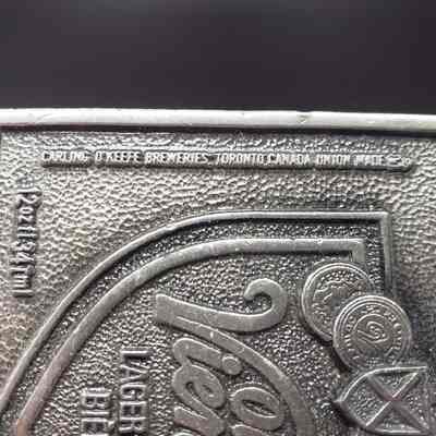 Belt Buckle] Old Vienna Lager, 1978 - Close-Up Left Text: Close-up view of vertical text on the left of the front