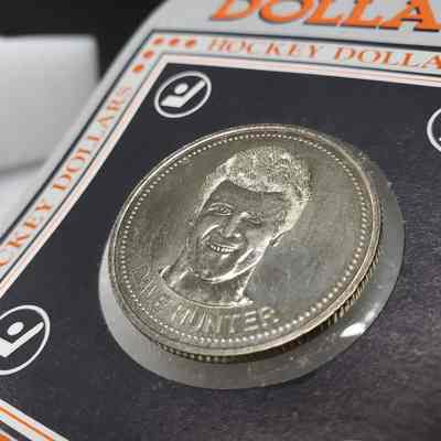 [Coin] 12 Dave Hunter/Edmonton Oilers, Hockey Dollars, 1983, In Packaging - 'Heads' Close-Up Angled: Angled close-up view of the 'heads' face of the coin, showing colouring
