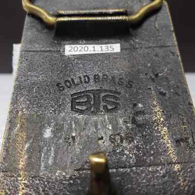 [Belt Buckle] Alberta Perforators Inc., Bronze - Maker's Mark: Close-up of maker's mark on back.
