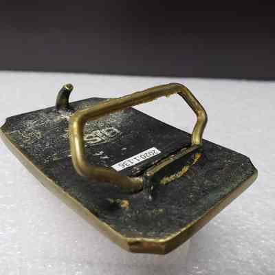 [Belt Buckle] Alberta Perforators Inc., Bronze - Hinge, Raised: Angled view of hinge, in raised position.