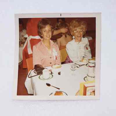 [Photo] Two Ladies Seated at a Dining Hall Table, Association of Desk and Derrick Clubs, Square, White Border, c.1972