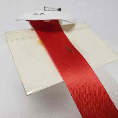 View of ribbon back with staple securing the name badge