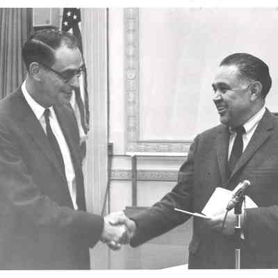 Robert Bennett shaking hands with unknown man