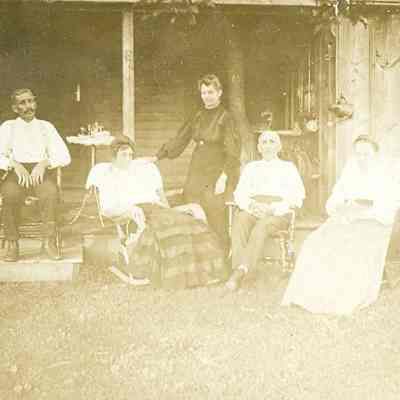 Five adults in front of house