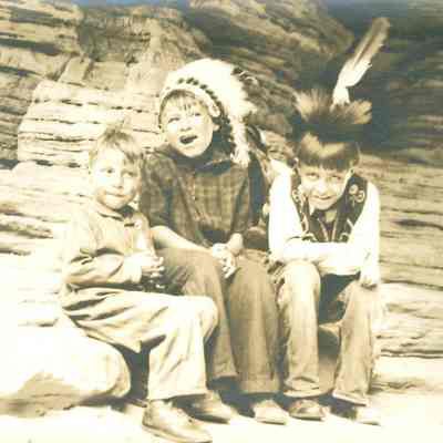 Three young boys by a rock wall