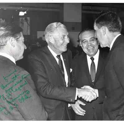 Four men greeting each other