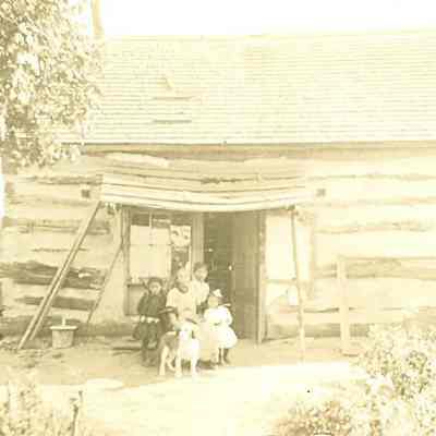 Children, woman, and dog in front of house - "Charlotte Patter"