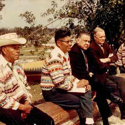 Six men sitting on a log