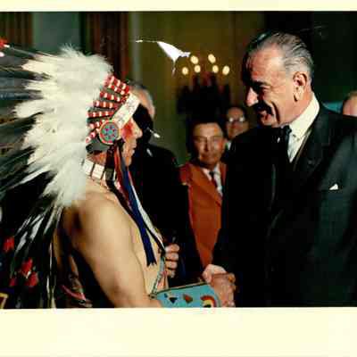 President Johnson shaking hands with Native in headdress