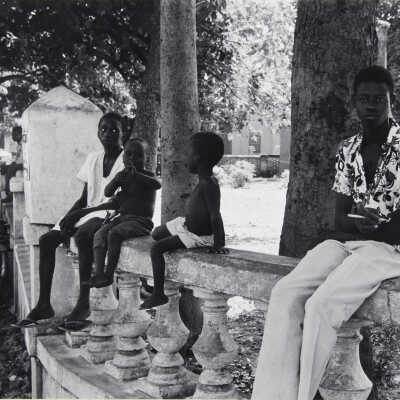 Untitled (four children sitting on stone banister)