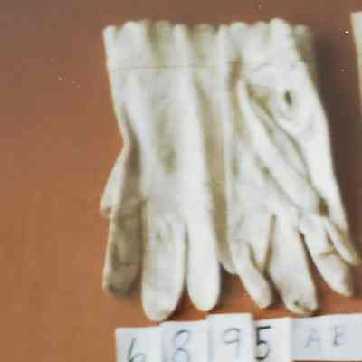 Short White Leather Gloves. Triple row of Stitching on back. Two Rows of Scallops at Wrist, Two Pearlized Button Closure