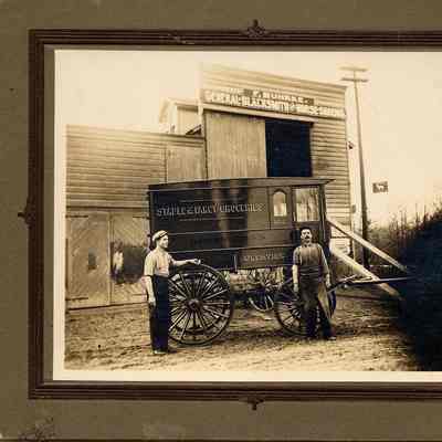 PH-0068: Buhrke Blacksmith shop with 2 men and Rugen Bros. Wagon
