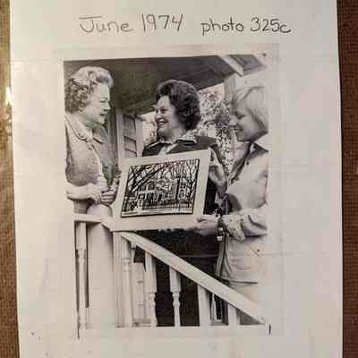 Photo attached to the back of the needlepoint. Depicts the gift to the Historical Society from the League of Women Voters.