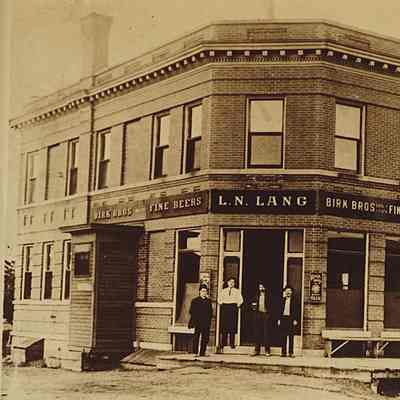 PH-1209-L.N. Lang Tavern 1902, wooden sidewalk; later became Rugen's “Birk Bros. Fine Beers”