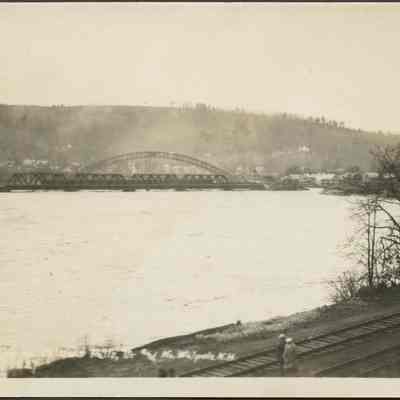 Body of Water Surrounded by Railroad Tracks and a Town