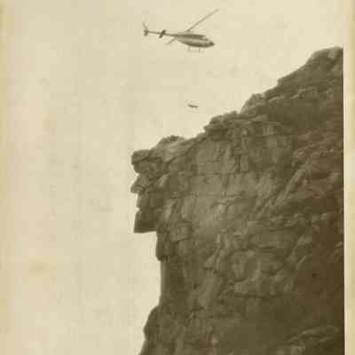 A Helicopter Flies Over The Old Man of the Mountain