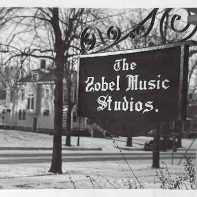 The Zobel Music Studios sign at the Zobel home, 603 Watson St.: Original photo in archive box 2006.0403.0002, folder "Zobel Music Studios"