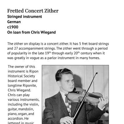 Exhibit label with Chris Wiegand playing the violin.