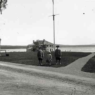 Coe_Family_013: William Rogers Coe, Henry H.R. Coe, and Robert D. Coe standing in front of house by water in Fairhaven
