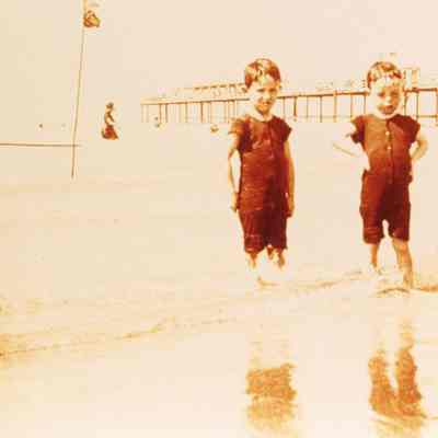 Coe_Family_015: William Rogers Coe and Robert D. Coe in swimsuits on a beach with pier