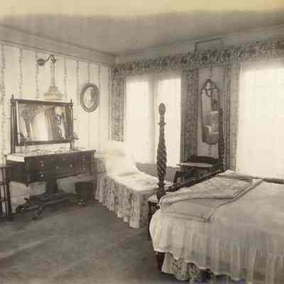 Byrne_029: Interior of bedroom with bed and lounge chair, photographed by August Patzig