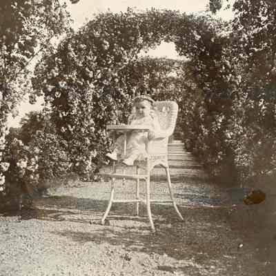 Coe_Natalie_004: Natalie Coe as a baby sitting in wicker high chair