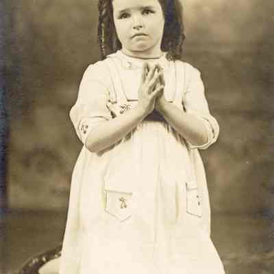Coe_Natalie_016: Portrait of Natalie Coe kneeling with palms together