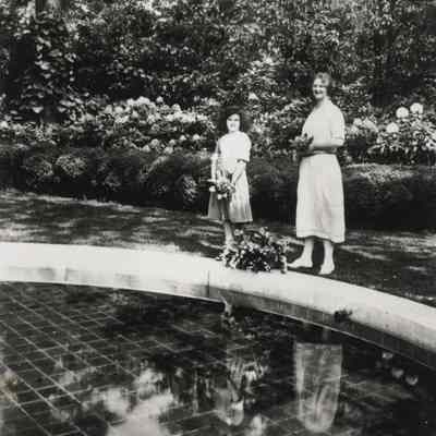 Coe_Natalie_018: Natalie Coe with unknown woman in front of garden pool