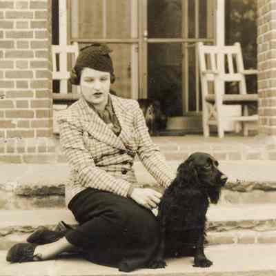 Coe_Natalie_035: Natalie Coe sitting on steps with black dog